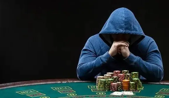 the man in the hood is playing poker.